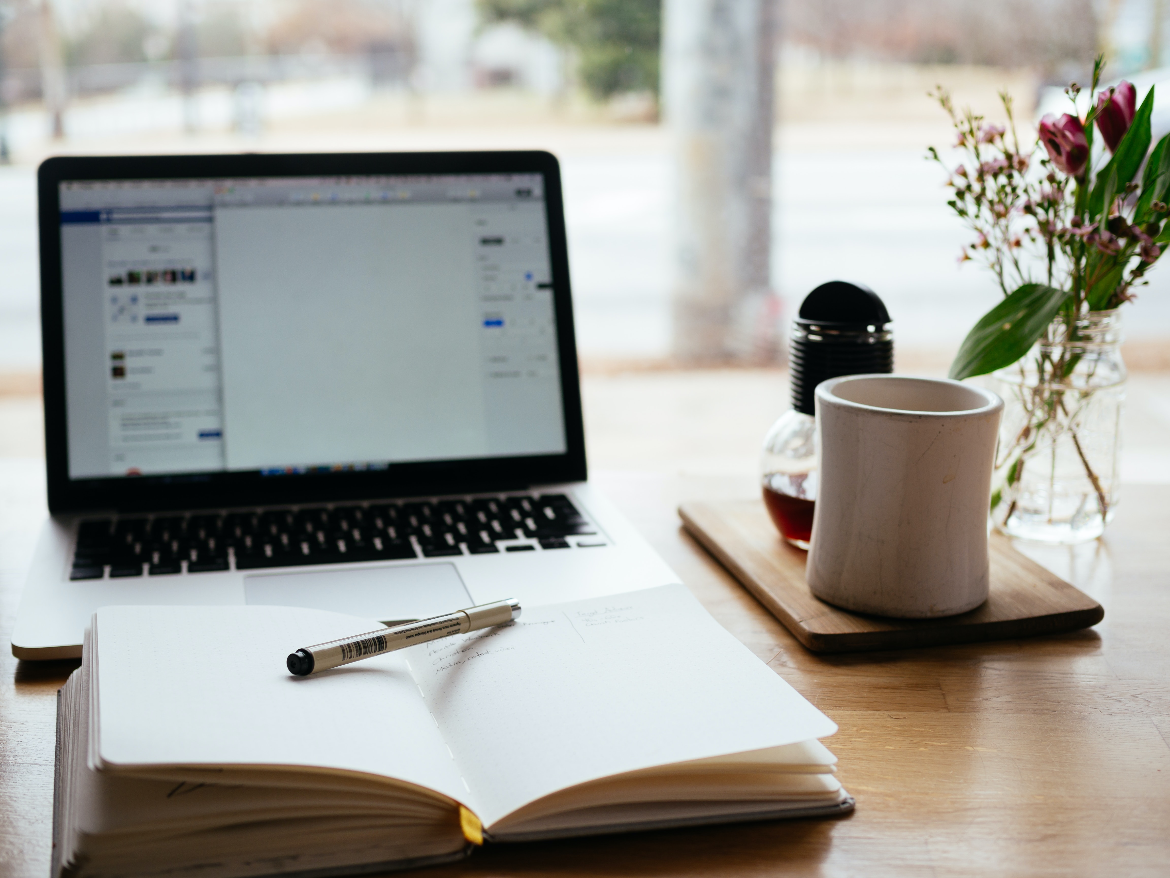 A laptop and a notebook on a desk